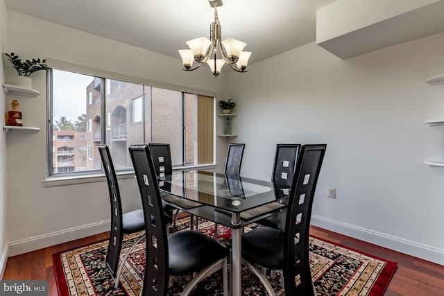 dining area featuring a notable chandelier and dark hardwood / wood-style flooring