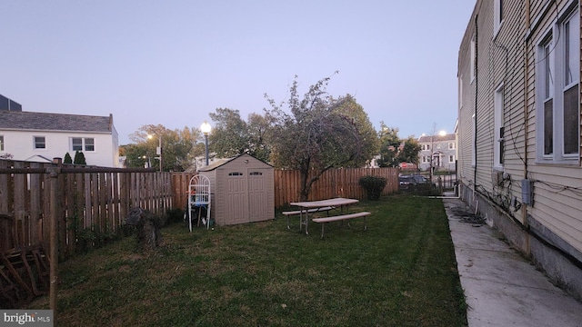 yard at dusk featuring a shed