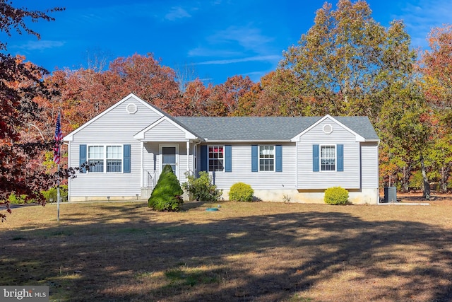 single story home with central AC unit, roof with shingles, and a front yard