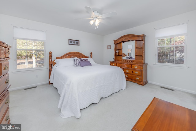 bedroom featuring baseboards, visible vents, and light colored carpet