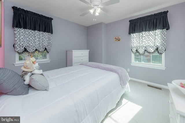 carpeted bedroom featuring baseboards, visible vents, and ceiling fan