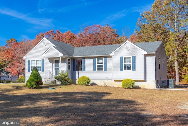 view of front of home featuring a shingled roof, a front lawn, and cooling unit