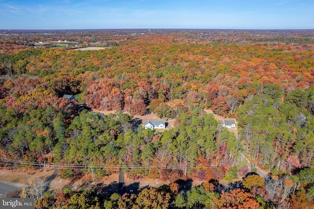 drone / aerial view with a wooded view