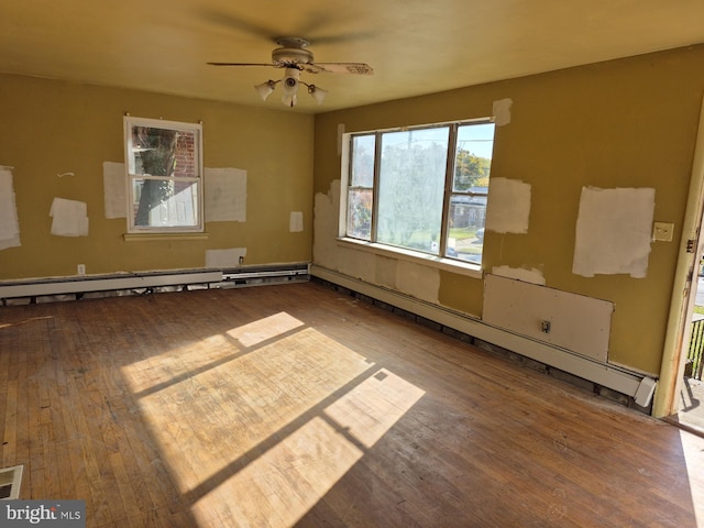 empty room featuring a baseboard heating unit, hardwood / wood-style flooring, and ceiling fan