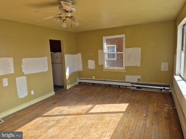 spare room with a baseboard heating unit, hardwood / wood-style flooring, and ceiling fan