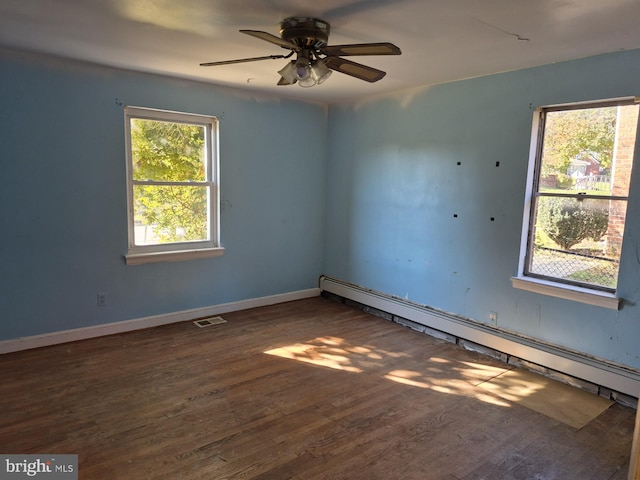 unfurnished room with a baseboard heating unit, ceiling fan, and dark hardwood / wood-style flooring