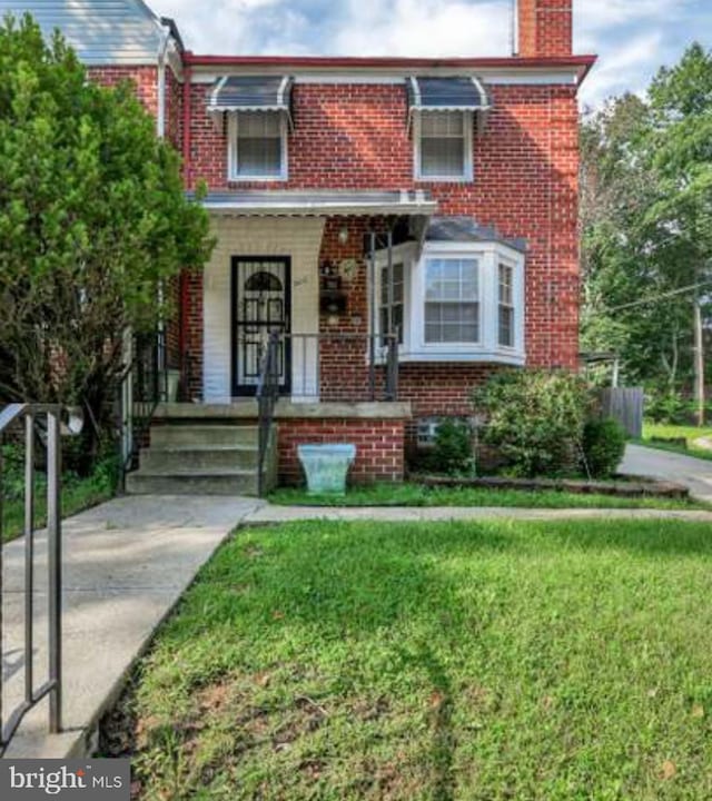 multi unit property with covered porch and a front lawn