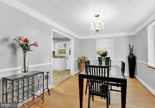 dining area featuring light hardwood / wood-style floors and an inviting chandelier