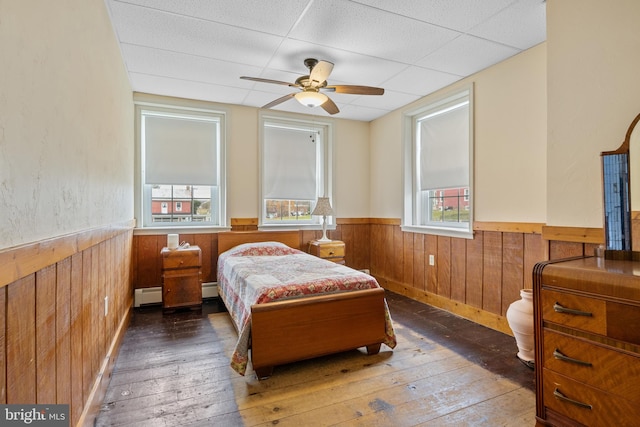 bedroom featuring dark hardwood / wood-style flooring, multiple windows, and ceiling fan