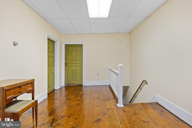 hall featuring hardwood / wood-style flooring and a paneled ceiling