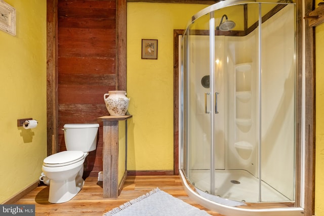 bathroom featuring wood-type flooring, toilet, and walk in shower