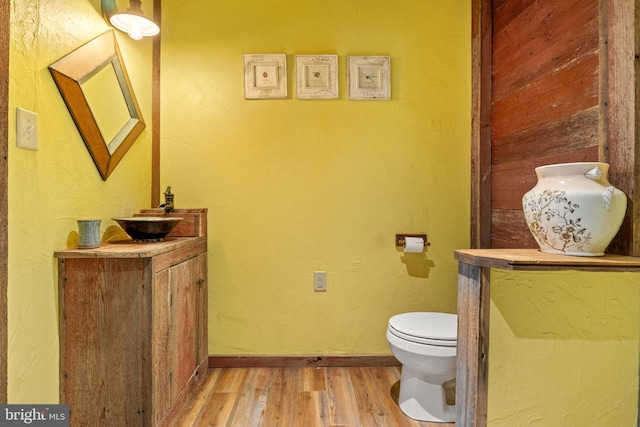 bathroom with hardwood / wood-style floors, vanity, and toilet