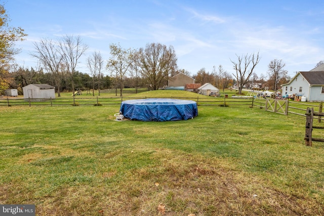 view of yard with a rural view and a covered pool