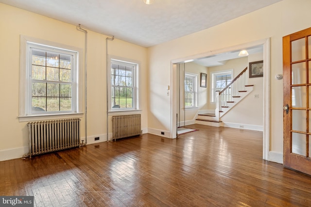 unfurnished room featuring radiator and hardwood / wood-style floors