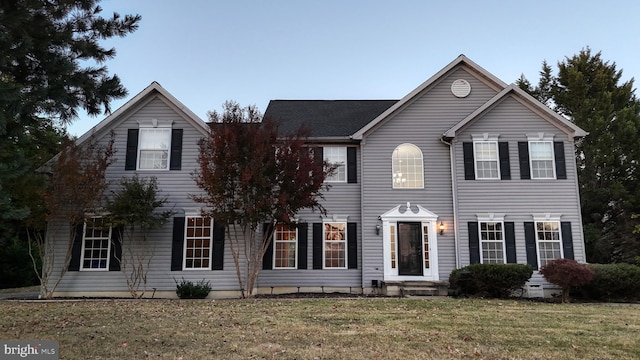 colonial house featuring a front lawn