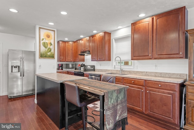 kitchen featuring dark hardwood / wood-style flooring, a center island, stainless steel appliances, and sink