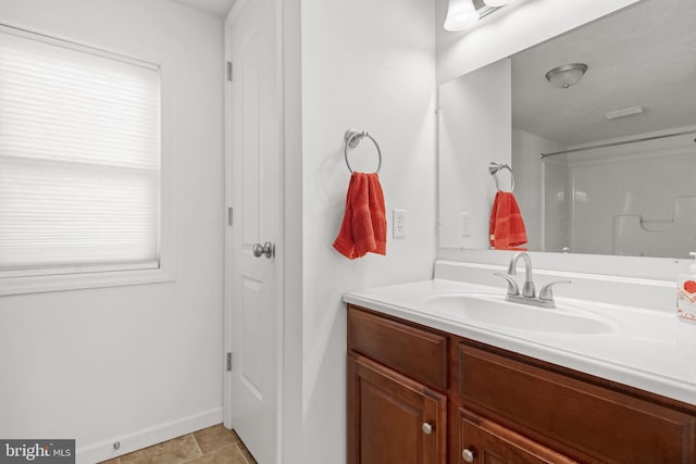 bathroom with tile patterned floors, vanity, and walk in shower