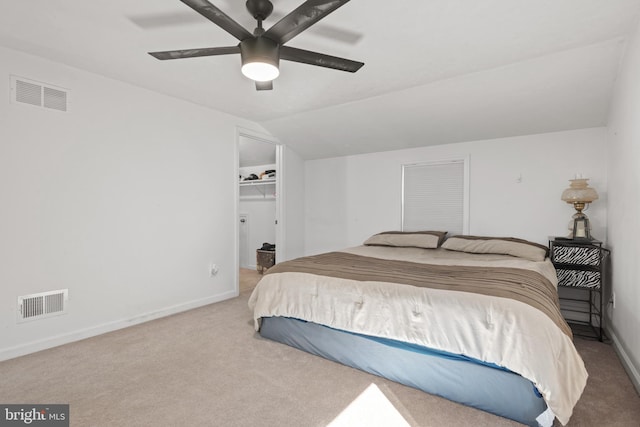 carpeted bedroom with a closet, a spacious closet, ceiling fan, and lofted ceiling