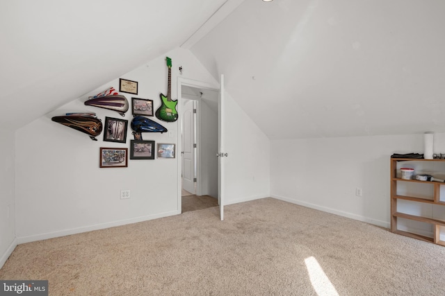 bonus room with light colored carpet and vaulted ceiling