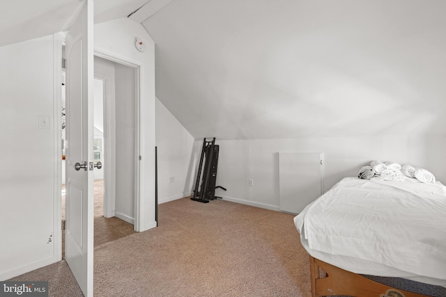 bedroom featuring light colored carpet and vaulted ceiling