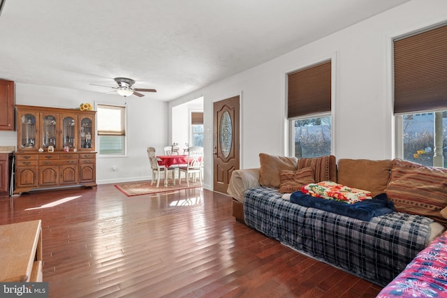 living room featuring dark hardwood / wood-style flooring, a wealth of natural light, and ceiling fan