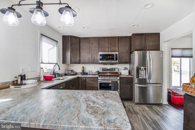 kitchen with dark brown cabinetry, sink, stainless steel appliances, and plenty of natural light