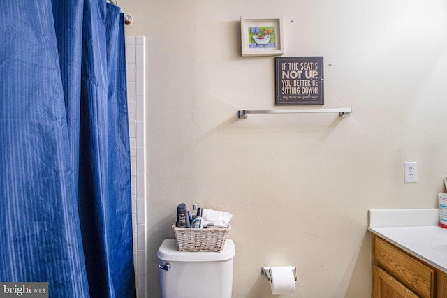 bathroom with a shower with curtain, toilet, and vanity