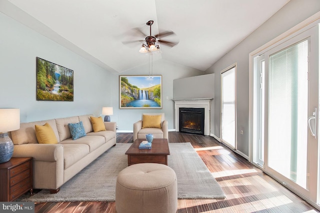 living room with hardwood / wood-style floors, ceiling fan, and vaulted ceiling