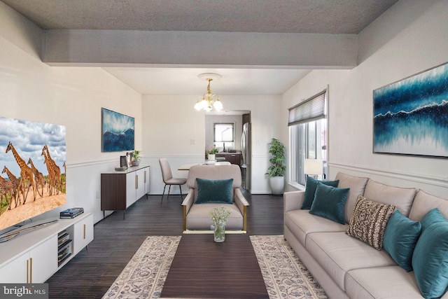 living room with a textured ceiling, a chandelier, and dark hardwood / wood-style floors