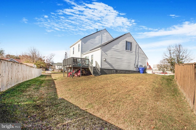 rear view of property with a deck and a lawn