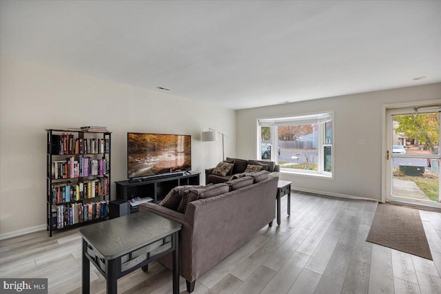 living room with plenty of natural light and light hardwood / wood-style flooring