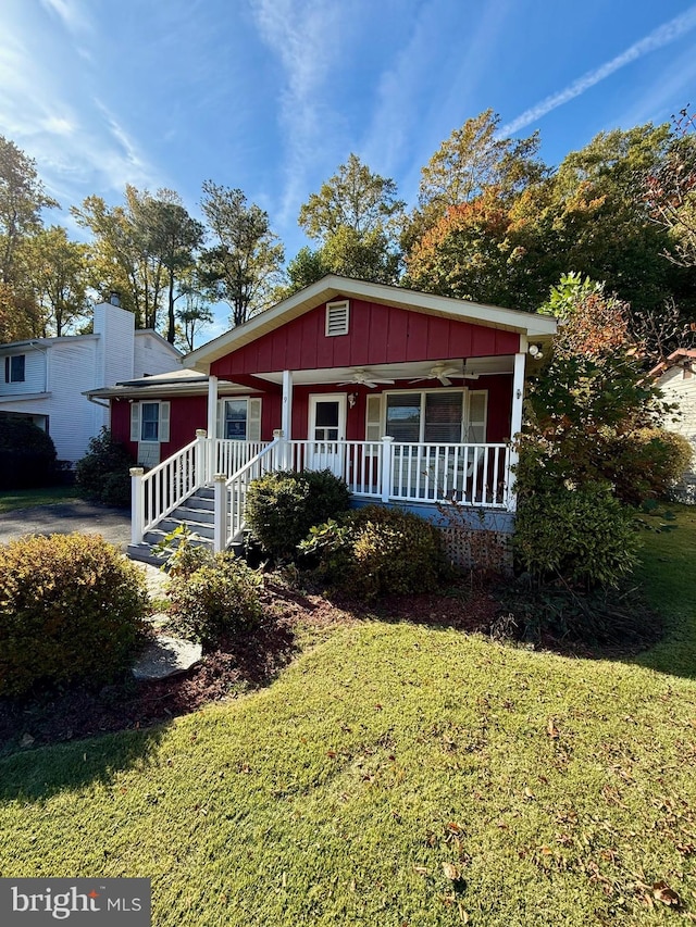 view of front of property featuring ceiling fan, a front lawn, and covered porch