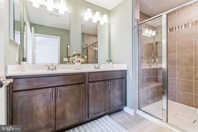 bathroom featuring vanity, a shower with shower door, and tile patterned floors