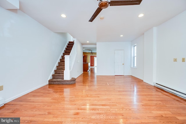 unfurnished living room featuring light hardwood / wood-style flooring, a baseboard heating unit, and ceiling fan