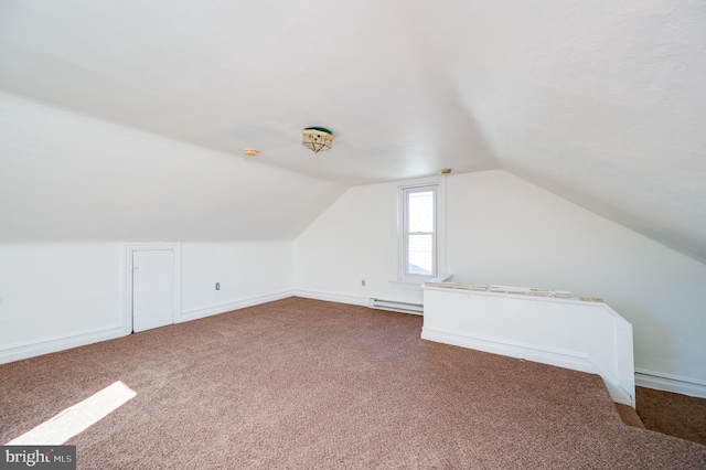 additional living space with a baseboard heating unit, carpet, and vaulted ceiling