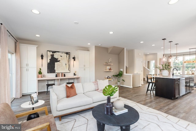 living room with light hardwood / wood-style floors and sink