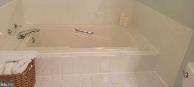 bathroom with tile patterned floors and tiled bath