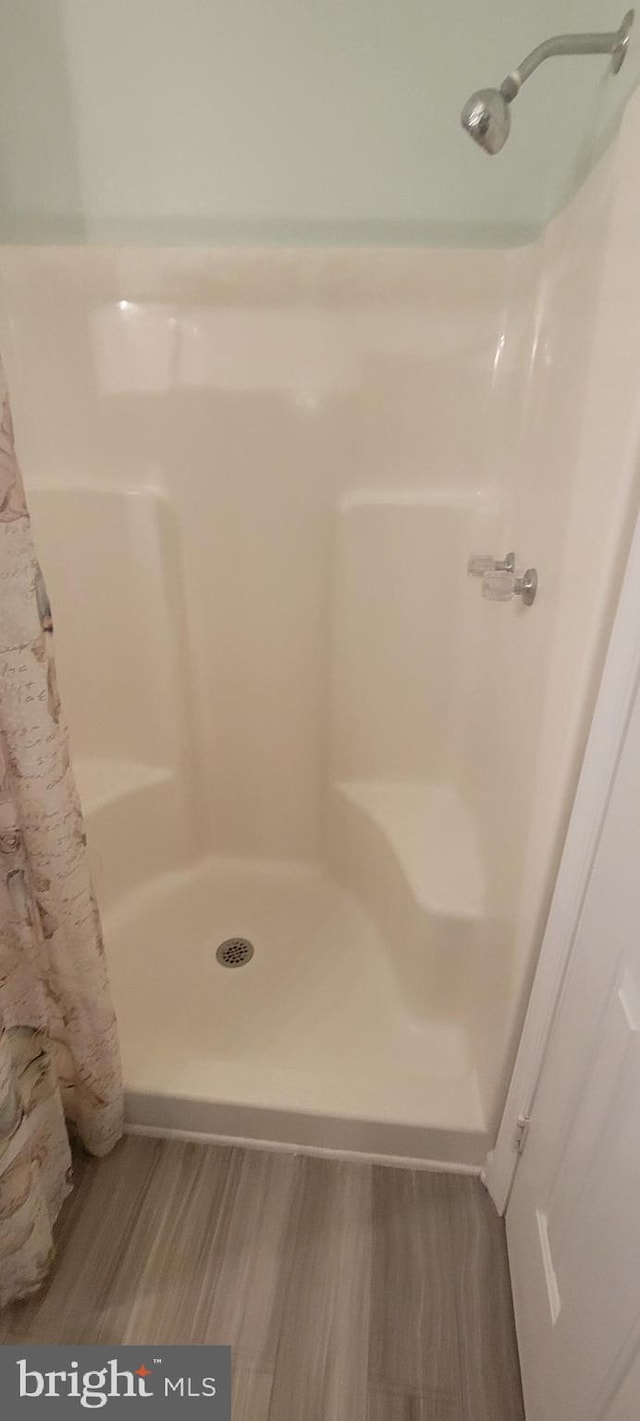 bathroom with a shower with curtain and hardwood / wood-style flooring