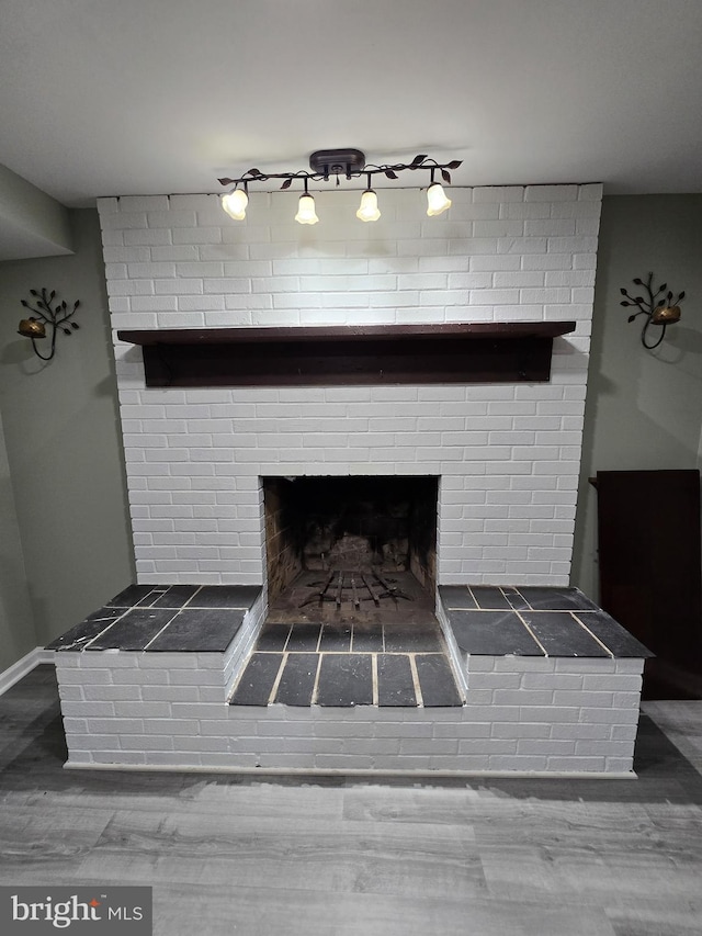 interior details featuring hardwood / wood-style floors and a brick fireplace