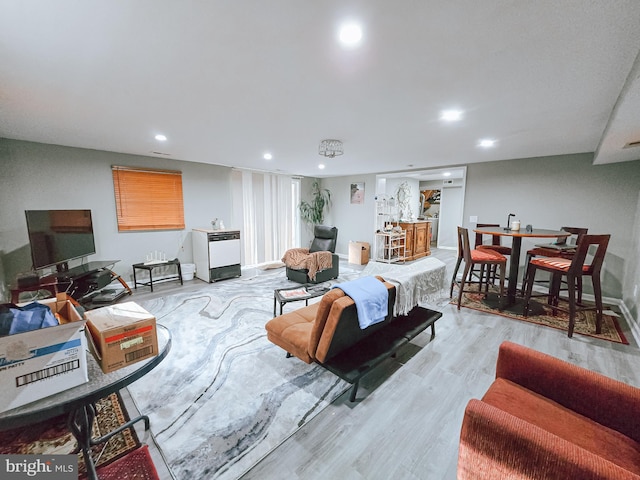 living room with light hardwood / wood-style floors and bar area