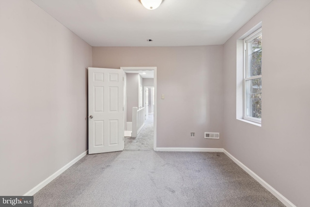 spare room featuring light carpet