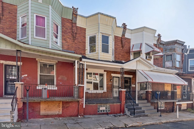 townhome / multi-family property with covered porch and cooling unit