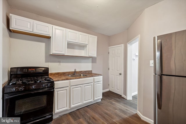 kitchen featuring dark wood-type flooring, stainless steel fridge, white cabinets, and black gas range