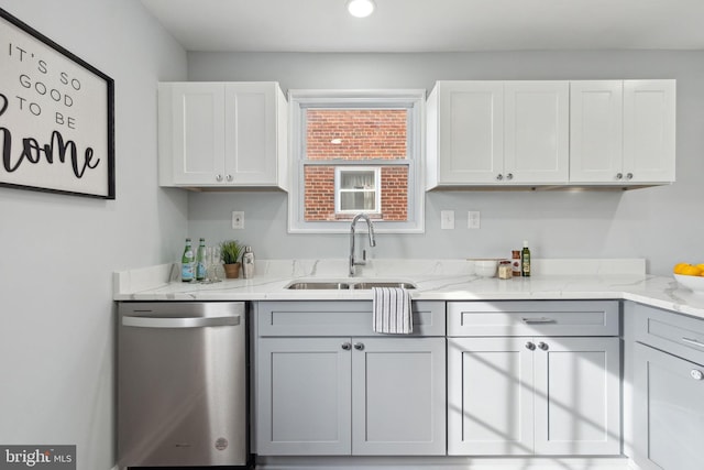 kitchen with gray cabinetry, light stone countertops, sink, stainless steel dishwasher, and white cabinets