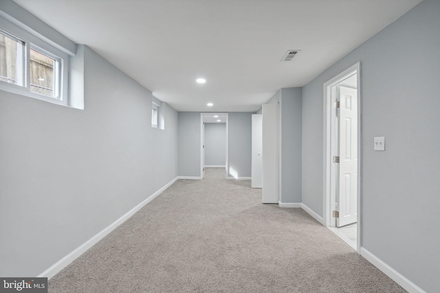 basement featuring light carpet and plenty of natural light