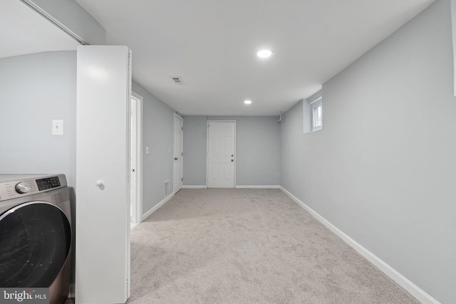 laundry room with light colored carpet and washer / clothes dryer