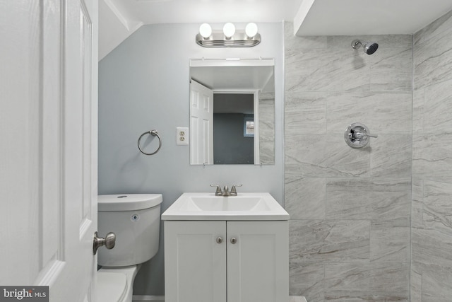 bathroom with vanity, a tile shower, and toilet