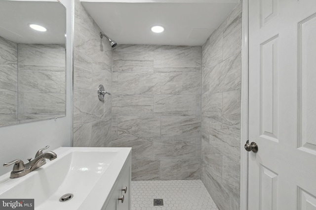 bathroom featuring vanity, a tile shower, and tile patterned flooring