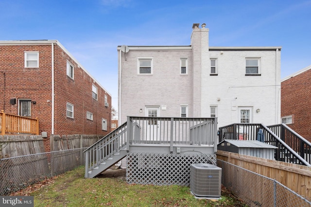 rear view of property featuring cooling unit and a deck