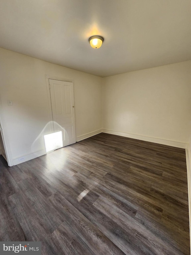 unfurnished room with dark wood-type flooring